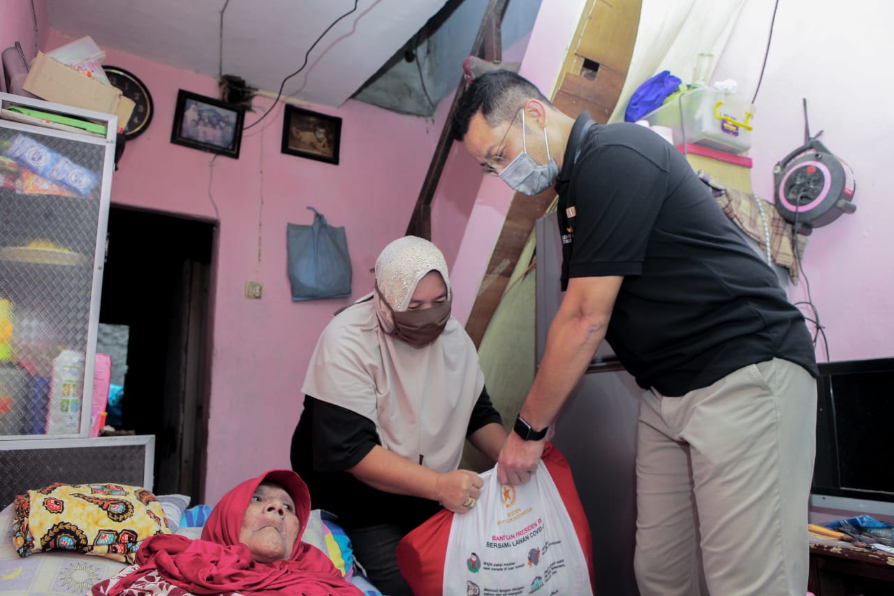 A Grandmother Receives Groceries from Social Minister